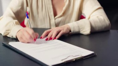 Araba galerisindeki müşteri kredi başvurusu ve finansman evraklarını tamamladıktan sonra kağıda imza atıyor. Galerideki müşteri finansal evrakları imzalıyor, kamera A yakın plan.