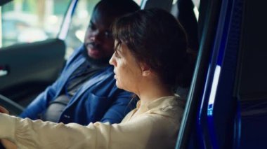 Deneme sürüşü sırasında araçtaki sorunları gözlemledikten sonra galeri satıcısıyla tartışan bir adam. Kocasının yanındaki direksiyonda üzgün bir kadın. Araba kullandıktan sonra fark edilen endişeleri anlatıyor. Kamera A.