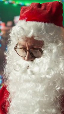 Kameraya gülümseyen neşeli yaşlı Noel Baba 'nın dikey video portresi Noel ruhu için heyecanlanıyor. Dünya 'nın dört bir yanındaki çocuklara oyuncaklar vererek Noel' i kutluyoruz.