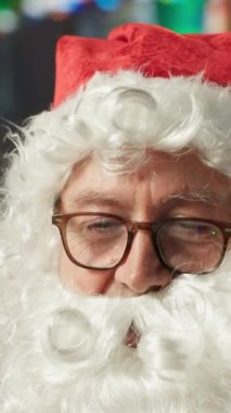 Dikey Videolu Noel Baba internette geziniyor. Bilgisayarını kullanarak dilek listelerini kontrol ediyor. Tatil neşesi ve online aktivitelerle dolu bir kulübe. Bu x mas, dünya haritasını kontrol ediyor.