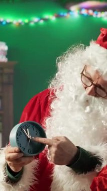 Dikey Noel Baba Noel arifesinde kütük kulübesinde duvar saati ile sihirli neşe ve bayram neşesini hissederek onu sergiliyor. Aziz Niklas, Kuzey Kutbu 'ndaki Noel kutlamalarını kutluyor.