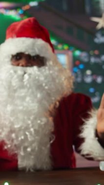 Dikey Videolu Noel Baba, çevrimiçi izleyicilerine Noel Baba 'nın büyüsü hakkında konuşan bir video bloğu kaydediyor. Festival kabinindeki Noel Baba, kış boyunca sosyal medya aracılığıyla abonelerle bağlantı kuruyor