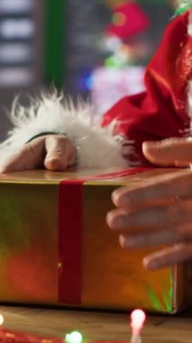 Dikey Noel Baba Noel Baba, Noel süslemeleriyle çevrili olan Kuzey Kutbu atölyesinde festival kağıdı ve kurdeleler kullanarak hediye kutusunu paketliyor. Noel Baba kış kutlaması için sürprizler hazırlar.