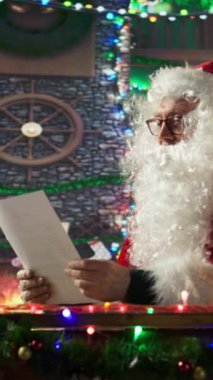Dikey Noel Baba, çocukların Noel mektuplarını okuyor. Noel Baba, Noel Baba 'nın güzel listedekilere hediyeler hazırladığı Noel' i neşeyle doldurdu.