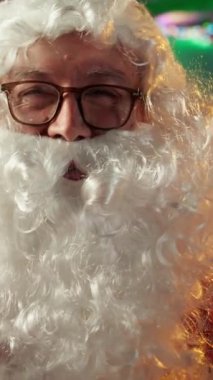 Aziz Nicholas 'ın dikey video görüntülerinde yaşlı adam çocuklara video konferansında el sallıyor, Noel dilekleri hediyelerini öğrenmek için çocuklarla ve ailelerle sohbet ediyor. Kuzey Kutbu kütük kulübesinde rahat oturuyor.