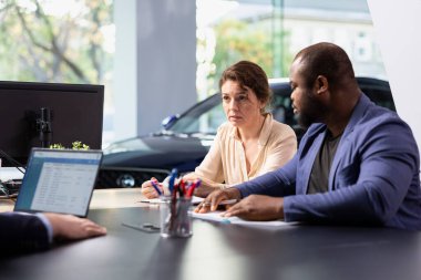 Araba satıcısı, ne tür bir araca yatırım yapacaklarını seçerken çiftlere karar vermelerinde yardımcı oluyor. Konsültasyon sırasında müşterilere doğru otomobili seçmelerinde yardımcı olan şov çalışanı