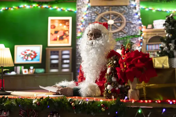 Noel Baba, süslü püslü atölyesinde bir mektup okuyor. Noel Baba 'ya yazılmış mektuplar Noel boyunca dilek ve çocukluk büyüsüyle dolu, x mas geleneği..