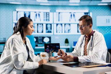 Doktor, tıbbi muayene sırasında kalemle insülin enjekte ediyor. Modern bir sağlık ofisinde tedavi gören Hintli hasta, tesiste diyabet teşhisi.