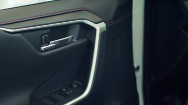 Kilidi açmak için paneldeki kilit kontrollerini kullandıktan sonra arabayı kapatan kişiyi yakın çekim yap. Otomobil sahibi, mekanizmayı kapatmak için düğme kullandıktan sonra kapı kolunu çekiyor