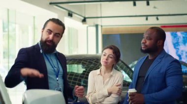 Araba satış temsilcisi bireylere ne tür bir araca yatırım yapacaklarına karar vermelerinde yardımcı oluyor. Showroom temsilcisi müşterilerine doğru aracı seçmeleri için yardım ediyor, kamera A
