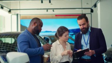 Araba galerisi satıcısı müşterilerle anlaştıktan sonra evrakları ve belgeleri tamamlıyor. Ajans, müşterilere araç anahtarı ve kamera A 'yı verdikten sonra imzalamaları için satış sözleşmesi veriyor.