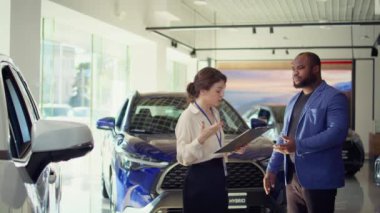 Pazarlık fiyatlarındaki satış elemanı ve anlaşmanın sağlamlaşmasına yardımcı olmak için ekstra araba özellikleri her satıştan komisyon ikramiyesi kazanıyor. Ajan tereddütlü müşteriyi araç almaya ikna ediyor, kamera B