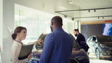 Kondisyon değerlendirmesi ve bilgi sağlandıktan sonra müşteriye kontörlü araç satan satış elemanı, ikinci el arabanın güvenilirliği ve bakımıyla ilgili müşteri kaygılarını ele alıyor, kamera B