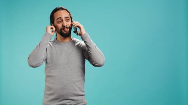 Olumlu duyguları olan neşeli bir adam telefon görüşmesinde arkadaşlarıyla konuşmaktan zevk alıyor. Akıllı telefon, stüdyo geçmişi. Yüzünde gülümseme olan mutlu insan, telefon görüşmesi sırasında iyi haberler alıyor, kamera B