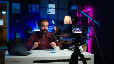 İçerik yaratıcısı rgb lights stüdyosunda online şov sunuyor, profesyonel ekipman kullanarak video bloğu çekiyor. Kamera B ile çekilen yayın sırasında bilgi sunan Vlog kaydedici