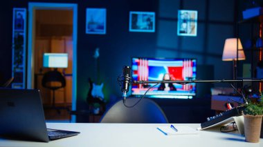TV ekranında boş stil neon ışıklı ev stüdyosunun içinde haber yayını ve mikrofon kaydı var. Modern dairede gece ve televizyon RGB ışıklarıyla aydınlatılmış canlı mikrofon.