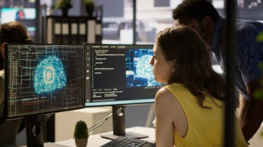 Çalışan yapay zeka teknolojisini kullanarak makinelerin verilerden öğrenmesini sağlayan algoritmalar tasarlıyor. Ofiste büyük ölçekli yapay zeka teknolojisi ve kamera A ile derin öğrenim modelleri yetiştiren bir yönetici.