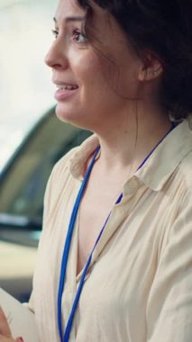 Dikey video bilgilendirmeli satış elemanı araba galerisinde soruları cevaplıyor ve kaliteli müşteri tecrübesi sağlıyor. Yeni araç ve kamera A için müşteriye tavsiye veren bilgili bir satış elemanı.