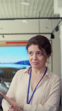 Dikey video bilgilendirmeli satış elemanı araba galerisinde soruları cevaplıyor ve kaliteli müşteri tecrübesi sağlıyor. Yeni araç arayışında müşteriye tavsiye veren bilgili satış elemanı, kamera B