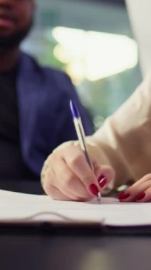 Araba galerisindeki dikey video müşterisi kredi başvurusu ve finansman evraklarını tamamladıktan sonra kağıda imza atıyor. Galerideki müşteri mali evrakları imzalıyor, B kamerasını kapat.