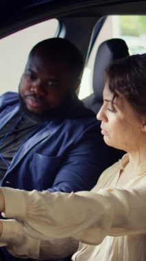 Dikey Videocu, test sürüşü sırasında araçtaki sorunları gözlemledikten sonra galeri satıcısıyla tartışıyor. Kocasının yanındaki direksiyonda oturan üzgün kadın, araba kullandıktan sonra fark edilen endişeleri anlatıyor.