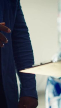 Dikey video Showroom satıcısı anlaşma bittikten sonra müşteriler için form imzalıyor, el sıkışıyor. Satış temsilcisi araç satışı, araba anahtarı ve kamera için belgeleri tamamlıyor.
