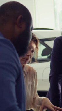 Araba kaputunun altındaki parçaları müşterilere gösteren dikey video pazarlamacısı motor gücünü gösteriyor. Araç yapımında kullanılan parçaları sunarak, müşterilerin otomobil seçmelerine yardımcı olan bir aracı