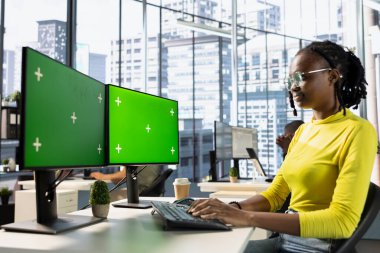 Ofisteki bilişim işçisi izole ekran bilgisayarındaki online iş belgelerine bakıyor. Çalışma alanındaki şirket çalışanı, iş yerinde üretken olmak ve bilgisayar modellemesi üzerine görevler yapıyor.