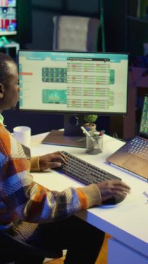 Dikey Video Afrikalı Amerikalı analist mali dengeyi kontrol ediyor ve muhasebe analizi üzerinde çalışıyor, yurtiçinde girişim geliri elde etmenin yollarını araştırıyor. Ekonomi istatistiklerini kullanarak uzaktan çalışma danışmanı