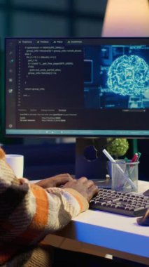 Dikey Video Afrikalı Amerikalı adam yapay zeka kullanarak bilgisayar üzerinde krom anahtarı olan bir yazılım sistemi geliştiriyor. Erkek bilişim programcısı kodlama ve siber güvenlik ve makine öğrenme yeteneğini gösteriyor.