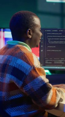 Dikey Video Afrikalı Amerikan Bilgi İşlem Uzmanı makine öğrenme, terminal penceresinde kodlama yazılımı için yapay zeka sistemini yönetiyor. Fütürist arayüz programı siber güvenlik ve ağ oluşturma üzerine odaklanır