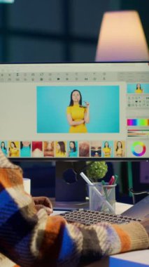 Dikey Video Afrikalı Amerikalı fotoğraf tasarımcısı, modern dijital medyayı temsil eden, teknoloji odaklı çevredeki çift ekran yeşil ekranların yanındaki görüntüleri rötuşluyor. Grafik sanatçısı yazılım araçları kullanıyor