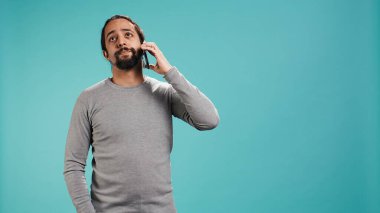 En iyi arkadaşla telefon görüşmesinde konuşan adam akıllı telefon ve stüdyo arkaplanı kullanıyor. Telefon görüşmesinde arkadaşla konuşan kişi cep telefonuyla stüdyonun arka planında izole edilmiş, kamera B