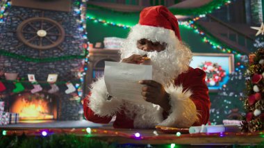 Kırmızı elbiseli Noel Baba çocukların mektuplarıyla zarfları açıyor. Kuzey Kutbu kulübesindeki çocukların dileklerini yerine getiriyor. Noel ruhunu yaymak için kış mevsimi kutlaması. Kamera B.