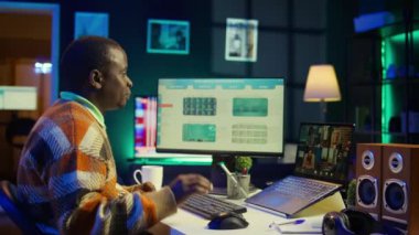 İnternetteki toplantı sırasında internet istatistikleri veya verileri hakkında konuşan Afrikalı Amerikalı bir adam. Freelancer sanal iletişim için teknolojiyi kullanıyor, uzaktan çalışıyor. Kamera B.