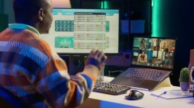 İnternetteki toplantı sırasında internet istatistikleri veya verileri hakkında konuşan Afrikalı Amerikalı bir adam. Freelancer sanal iletişim için teknolojiyi kullanıyor, uzaktan çalışıyor. Kamera A.