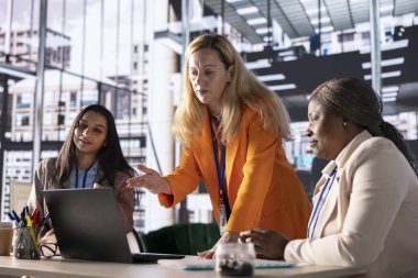 Modern bir çalışma alanındaki kadın yöneticiler iş stratejisi üzerinde işbirliği yapıyor ve verimli bir toplantı düzenliyorlar. Ekonomik bağımsızlığa odaklanan ve engelleri aşan başarılı iş kadınları.