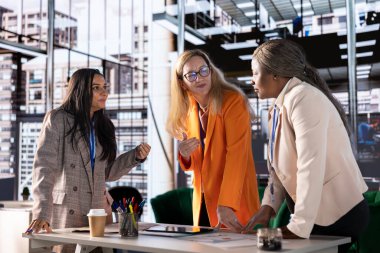 Modern bir ofiste işbirliği yapan kadın yöneticiler iş dünyasındaki kadınların verilerini analiz ediyorlar. CEO 'lar liderlik geliştirme stratejilerini tartışıyor ve birlikte mükemmelliğe ulaşıyorlar..