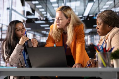 Modern bir ofiste işbirliği yapan kadın yöneticiler iş dünyasındaki kadınların verilerini analiz ediyorlar. CEO 'lar liderlik geliştirme stratejilerini tartışıyor ve birlikte mükemmelliğe ulaşıyorlar..