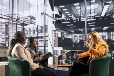 Stratejik bir toplantıda çeşitli iş kadınları kurumsal büyüme ve liderlik hedeflerini tartışıyor. Profesyonel ofis ortamında çok kültürlü liderler üretkenliği ve işbirliğini yönlendiriyor.