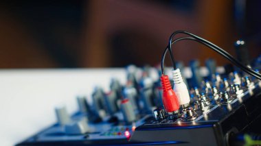DJ 'in ev yapımı kişisel stüdyosunda müzik yapmak ve çevrimiçi kayıt yapmak için kullandığı profesyonel radyo ekipmanlarının yakın çekim görüntüleri. Boş oturma odası. Neon ışıkları ve eğlence aleti var.
