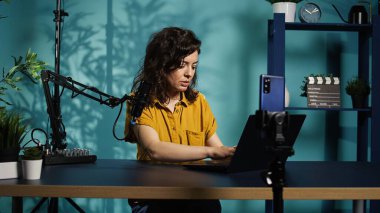 Streamer canlı yayında izleyicilere son günlerdeki haber başlıklarını anlatıyor, dizüstü bilgisayardan okuyor. İnternet şovu sunucusu izleyicilerle konuşuyor, not defterine bilgi sunuyor, kamera B