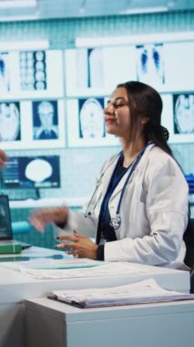 Dikey Video Hintli doktor ve hasta tıbbi danışmada el sıkışıyor sağlık kontrolünde sıhhiye geliyor. Modern klinikte sağlık hizmeti sağlayıcı hasta kişiye danışmanlık yapıyor. Kamera B.