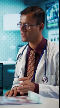 Dikey Video Hintli uzman, muayenehanedeki bir kadın hastayla test sonuçları üzerinden teşhis koymayı ve bir kadını kontrol etmek için tarama yapmayı açıklıyor. Sigorta konusunda sağlık hizmetleri