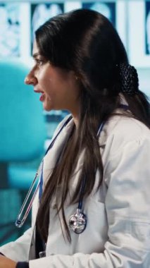 Dikey Hintli doktor ve hasta cilt bakımı sırasında cilt bakım ürünleri hakkında konuşuyor. Genç adama güneş kremi öneren kadın. SPF nemlendirici losyon önerisi. Kamera A
