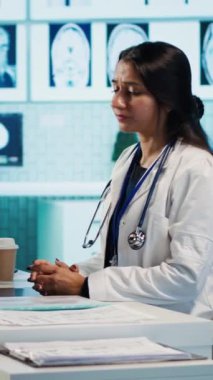 Dikey Görüntü Hindistanlı doktor, sağlık için destek ve reçeteli ilaçlar sunarak kontrol sırasında bir kutu ilave ve ve antibiyotik veriyor. Erkek uzman doğru dozajda hap öneriyor.