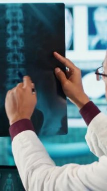 Dikey Görüntü Uzmanı doktor ve hasta röntgen ve MRI sonuçlarının taranması için sağlık kontrolüne giriyorlar. Genel pratisyen hekim, sağlık uygulamaları ve sağlık uygulamalarını vurguladı