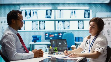 Hastaya antibiyotik ve vitamin reçetesi yazan pratisyen doktor doğru dozda ilaç öneriyor. Kadın doktor sigorta hakkında reçeteli bir belge yazıyor. Kamera B.