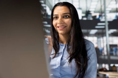 Hintli şirket yöneticisi uzaktan bir toplantıya katılır, performans ölçümlerini ve iş operasyonlarını gözden geçirir. Proje yönetimini düzene sokmak için dijital iletişim araçları kullanılıyor.