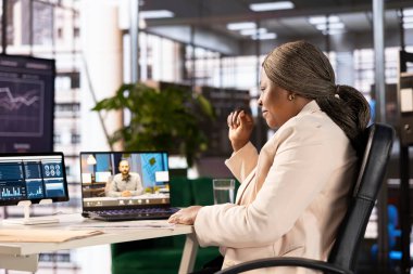 Modern ofisin takım lideri telekonferans toplantısında bölge müdürüyle konuşuyor. İş yerindeki Afrikalı Amerikalı iş kadını yönetici ile online video görüşmesi yapıyor.
